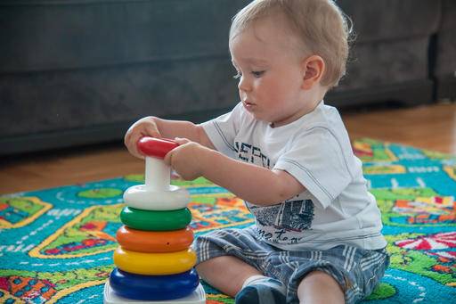 A toddler independently playing with his toy