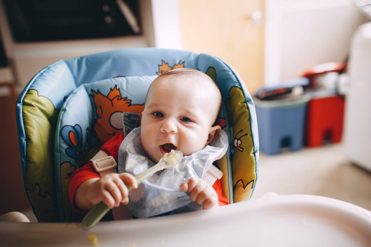 A baby eating with a spoon