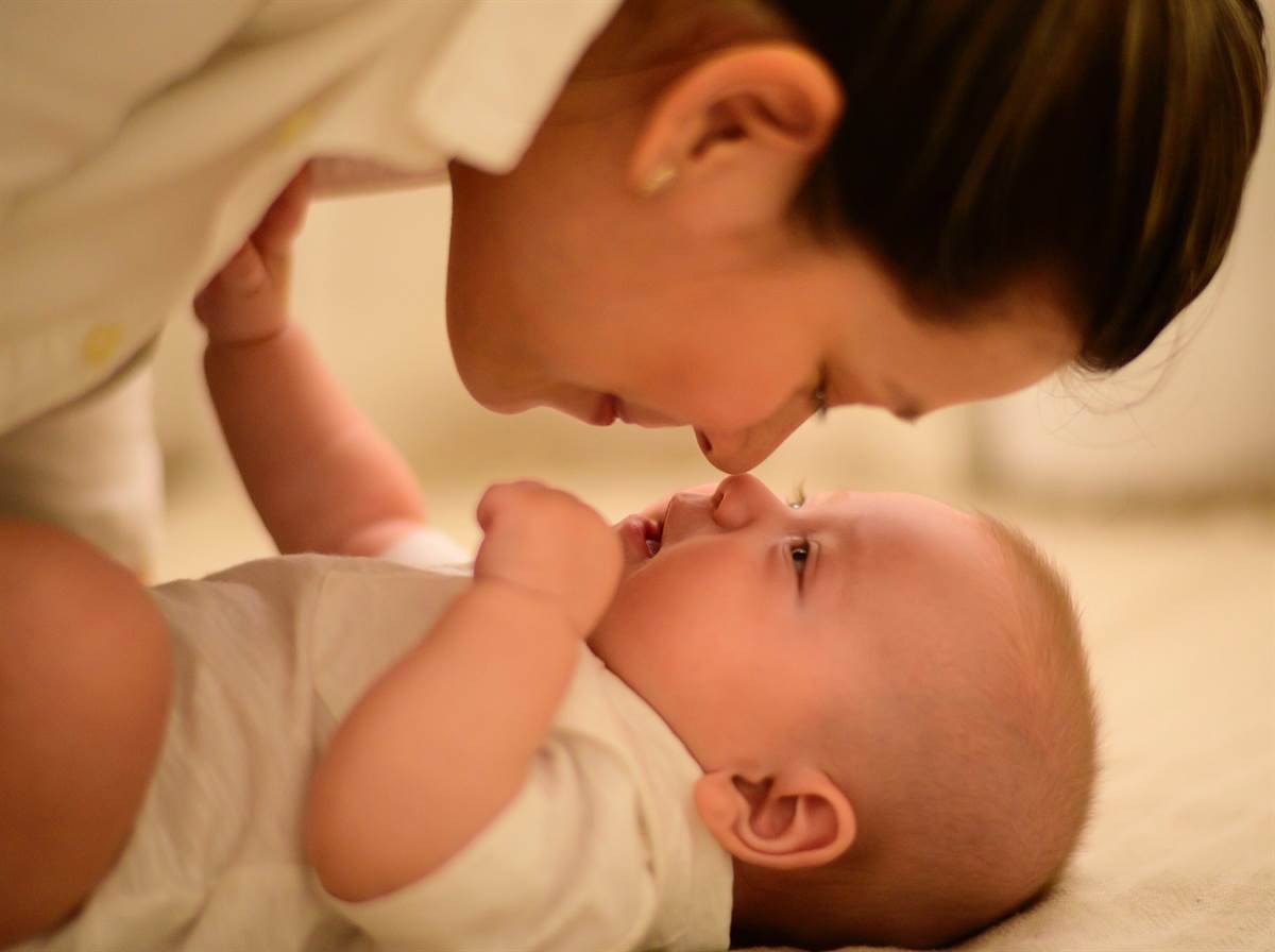 A baby and a mother smiling at each other