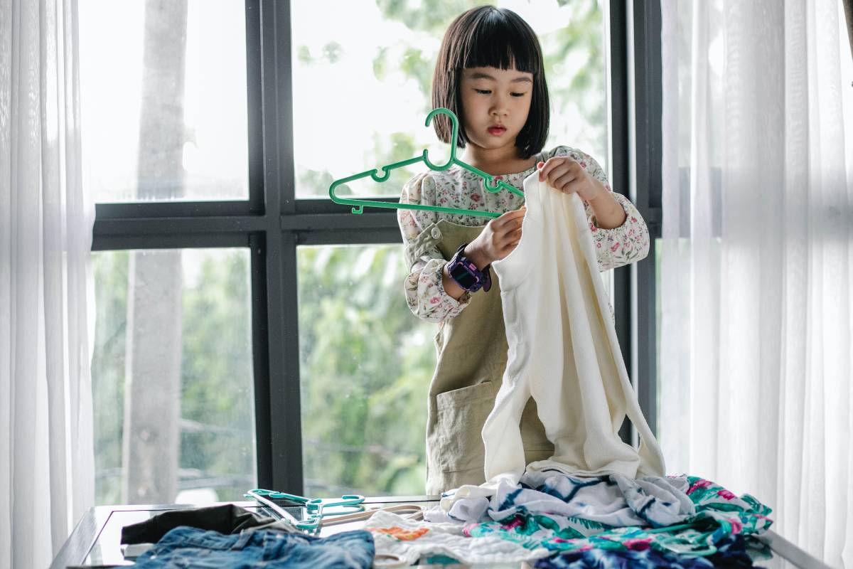 A girl hangs her clothes on a hanger 
