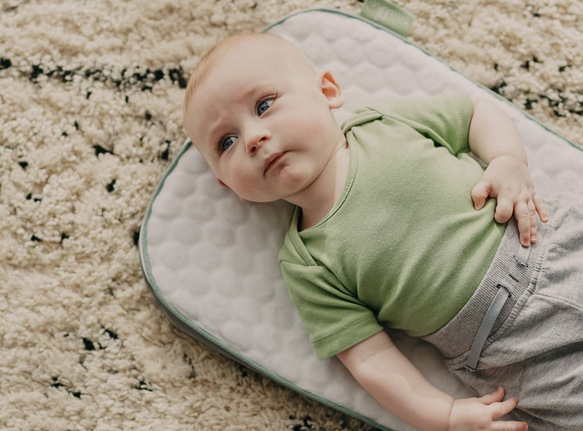A child is laying on her or his back and focusing her or his sight on something