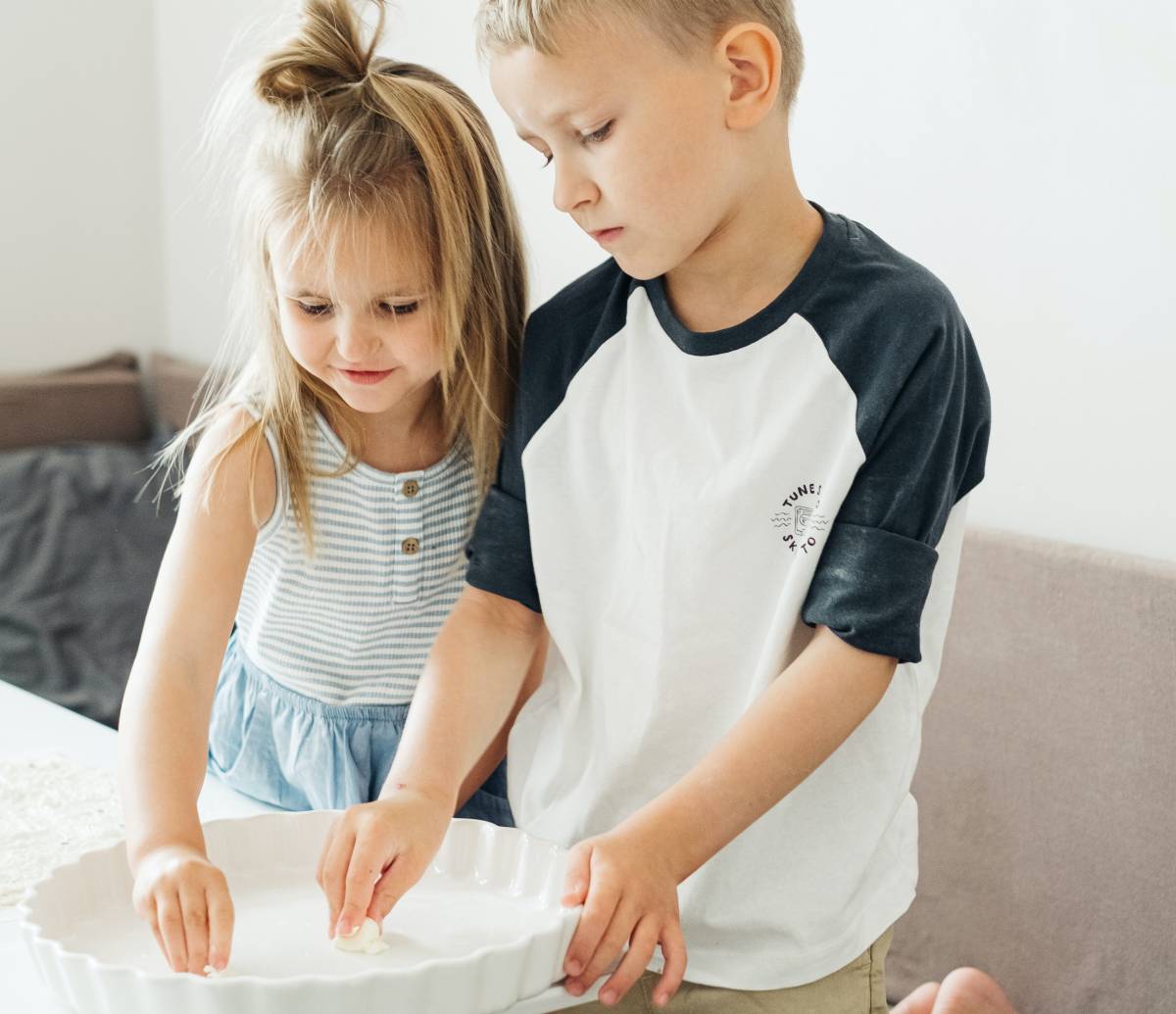 A sister and a brother preparing a pretend meal