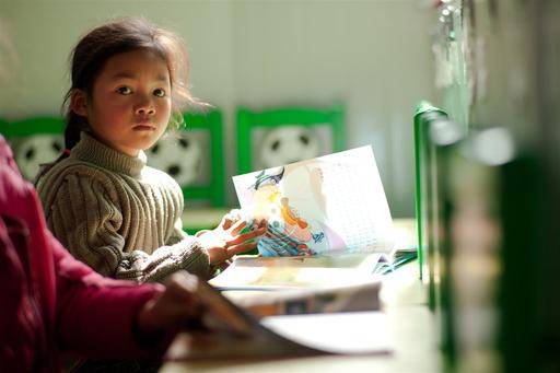 A child with a book ready to tell her story to parents