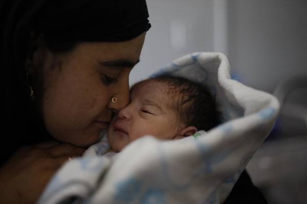 Happy mother kisses her baby.