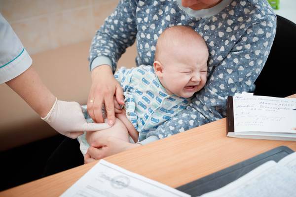 Baby with colic in his mother arms.