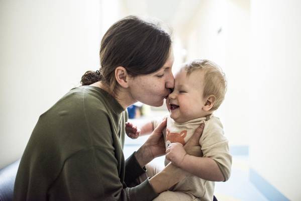 Mother kisses her son 9 months, after he received DTP vaccine.