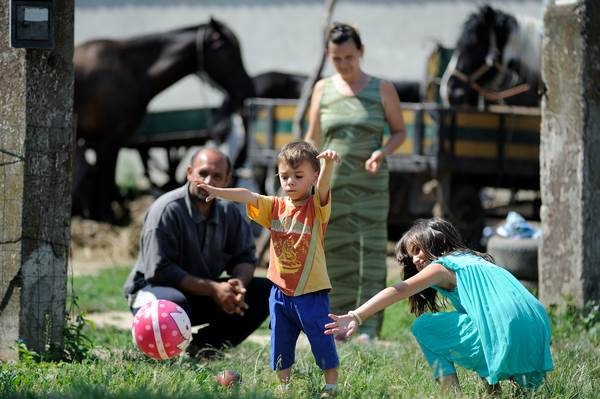 A family is playing in their front yard – father Zoran, mother Zorica and their children David (4 years old) and Aleksandra (9 years old).
