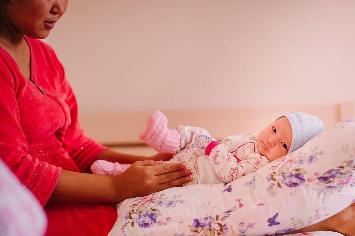 Mother playing with her newborn baby.