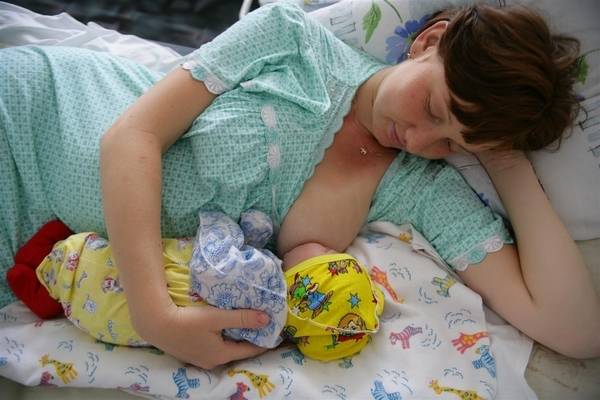 Mother breastfeeding her 2 days old daughter.