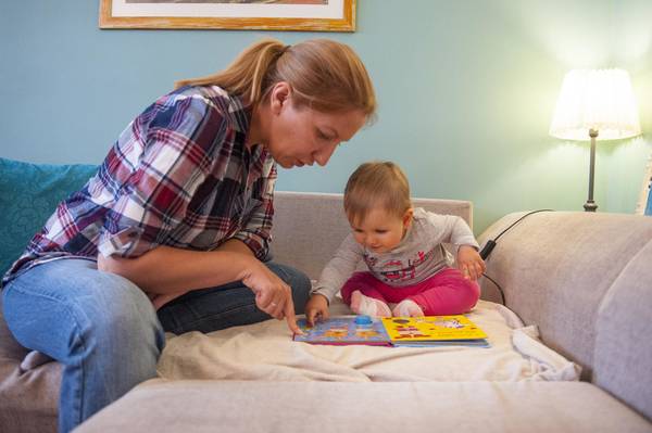 Mother and her baby are spending time together, playing and learning.