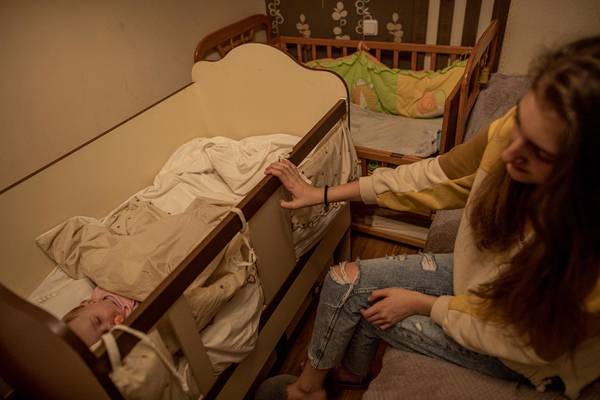 Sister puts her newborn sister to sleep.