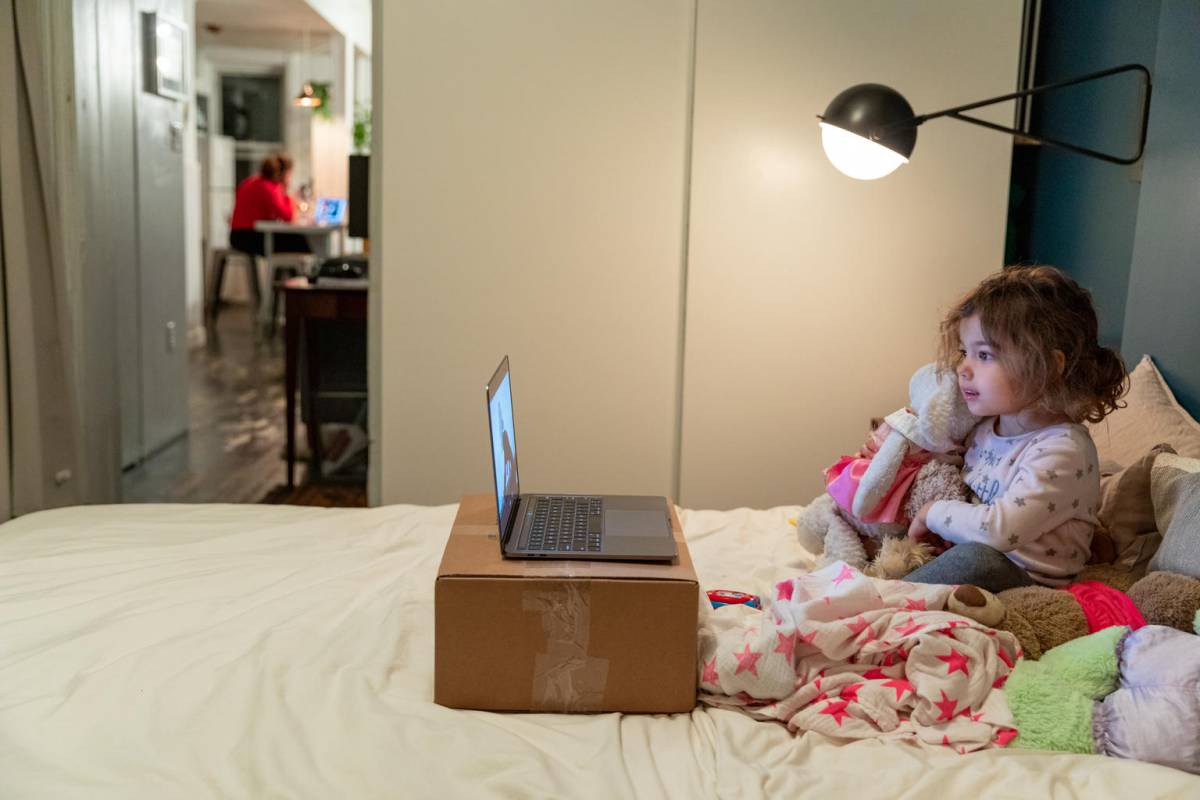 Girl on the computer and mother on the background also spending time in the computer.