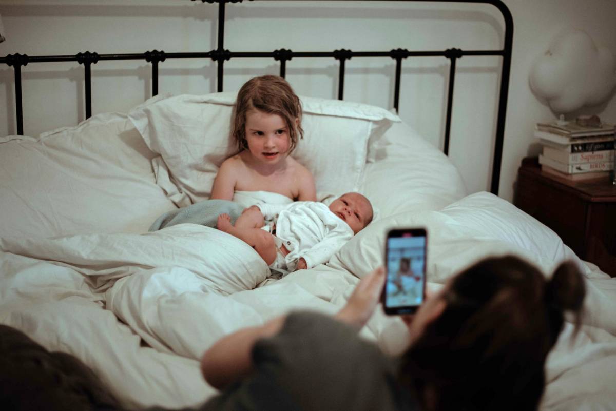 Mother taking pictures of her two kids to post it on internet.