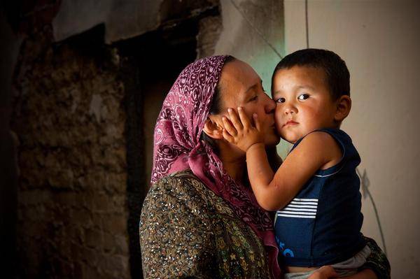 Mother kisses her three-year-old son.