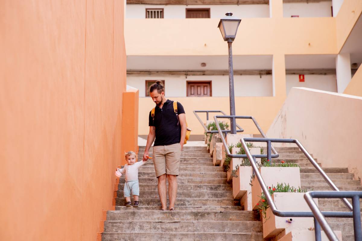 A father going down the stairs with his child.