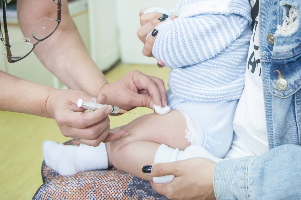 vidi se ruka medicinske sestre kako aplikuje vakcinu u butinu deteta