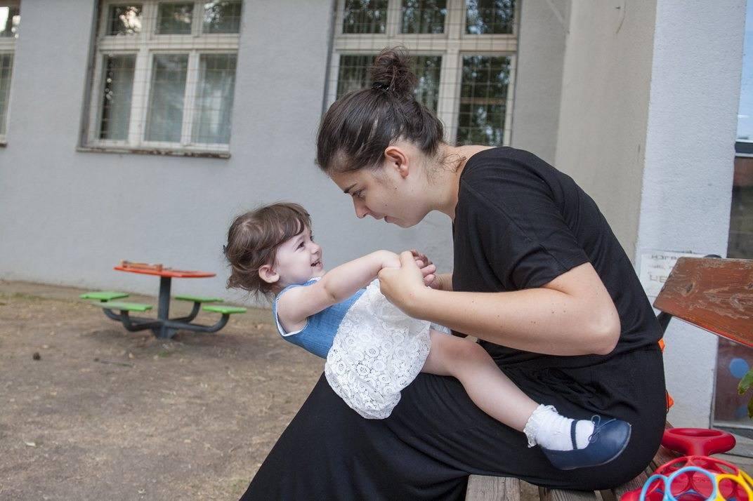 mama i devojčica se igraju balansiranja na maminom krilu