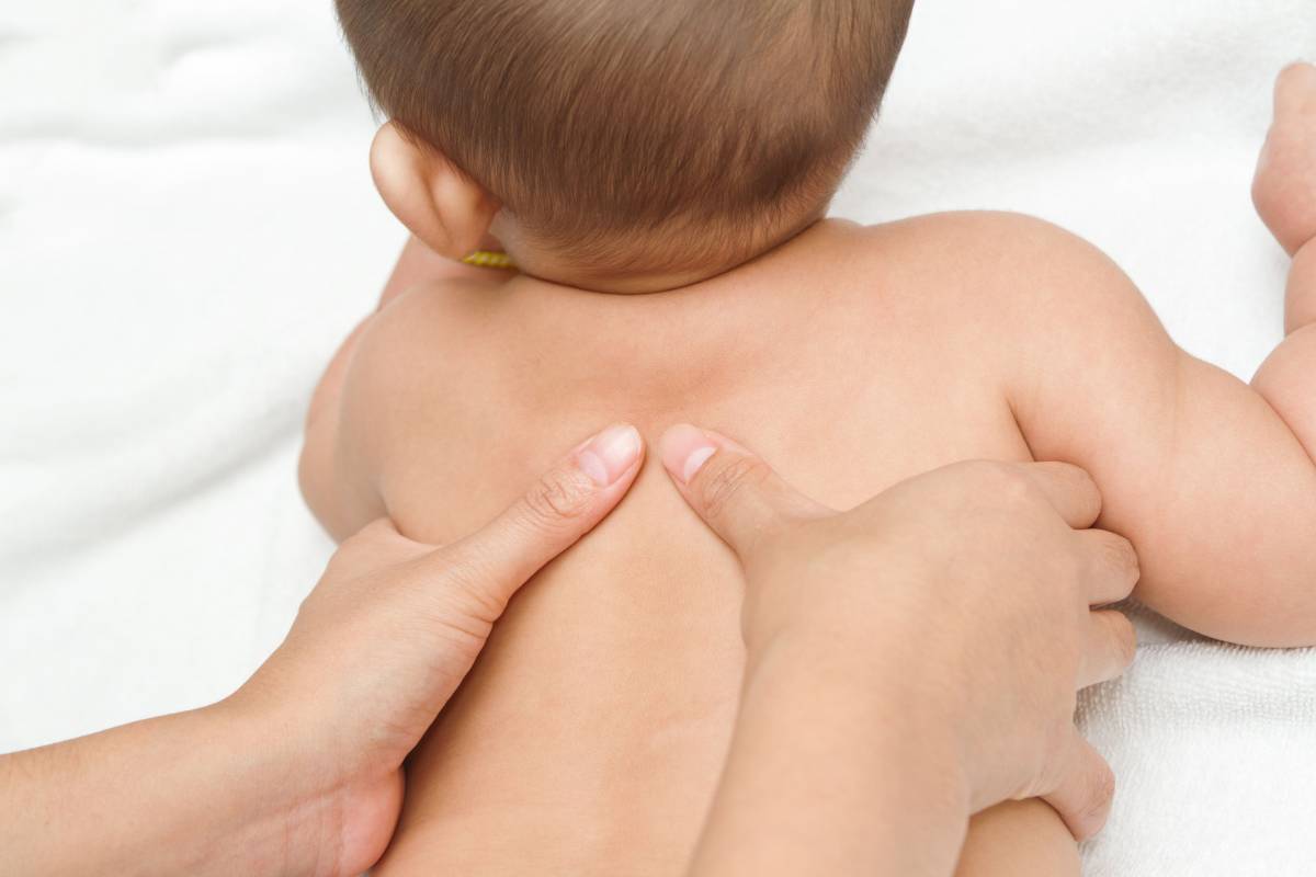 A parent making massage to a baby