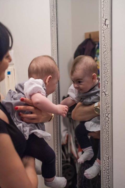 mama i beba pred ogledalom, beba je okrenuta ka ogledalu, komunicira neverbalno sa svojim likom u ogledalu
