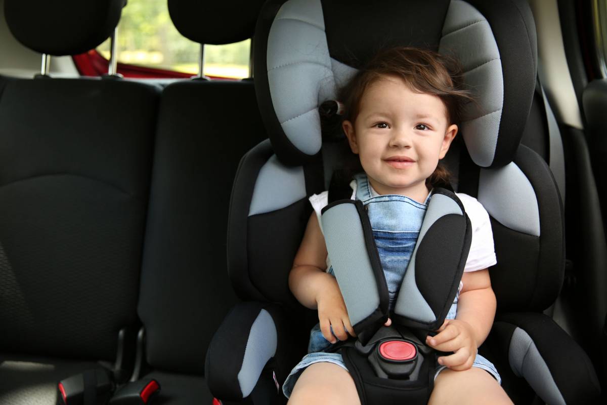 A child seating in a safety chair in the car