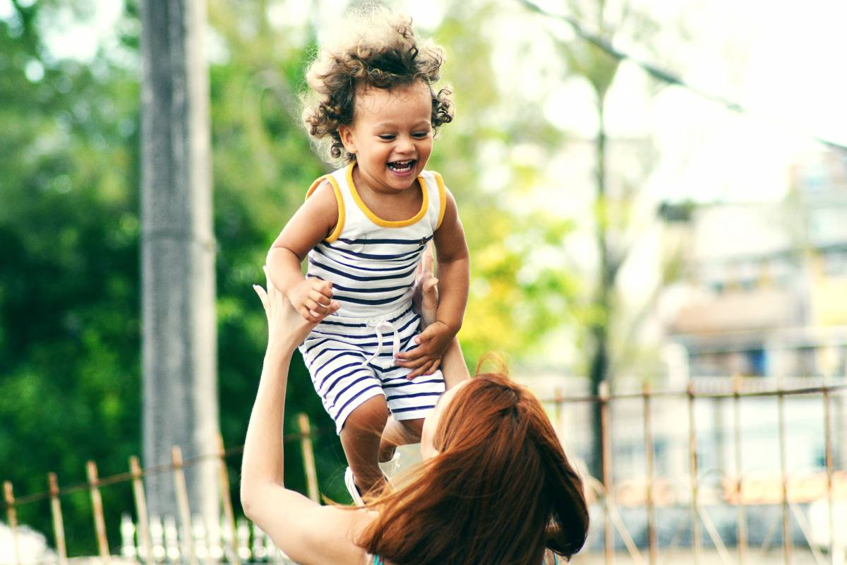 Mother holds/playing with her daughter (tips settling in at child care)