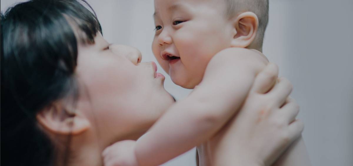 A mother blowing at her child's face