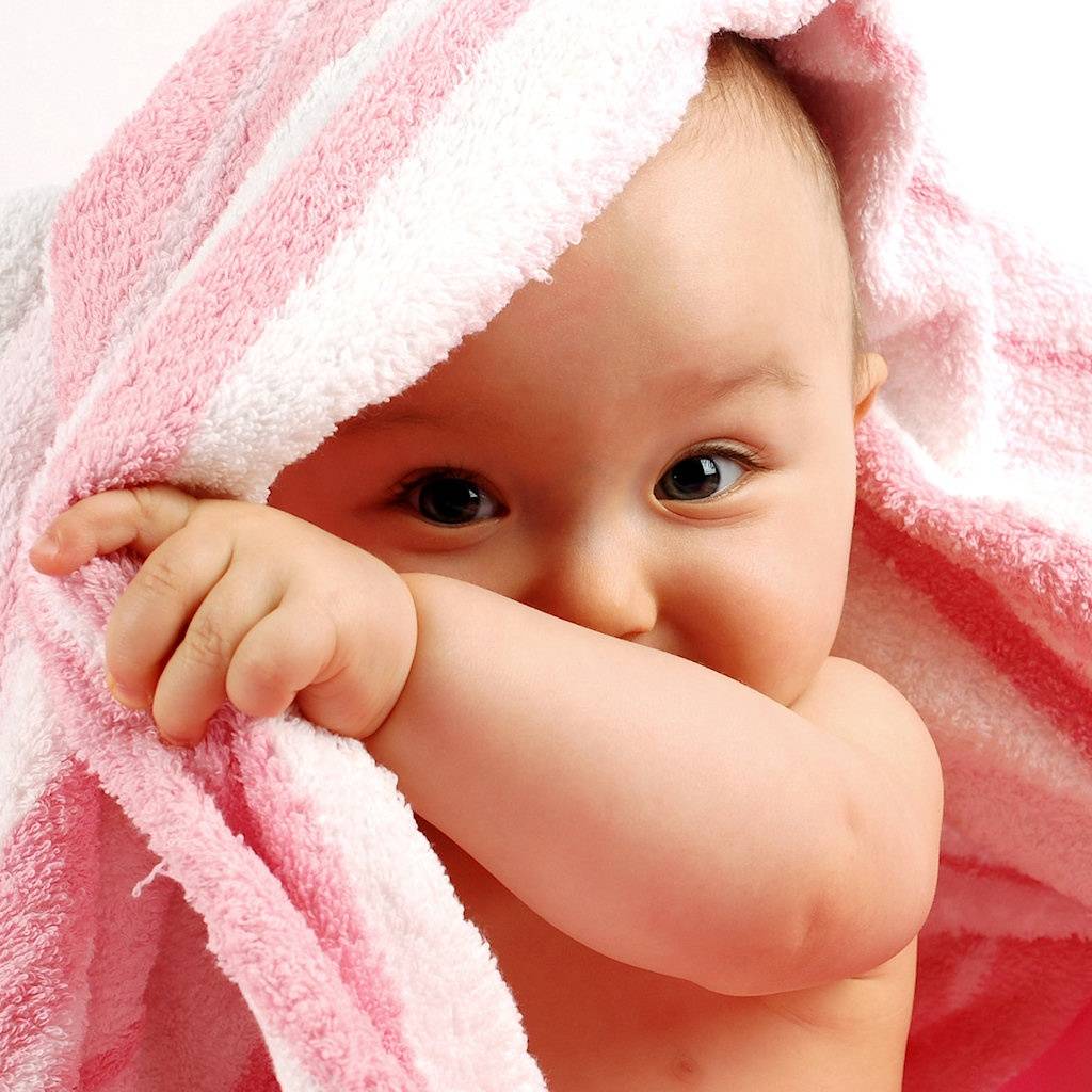 A smiling child looking out of the blanket 