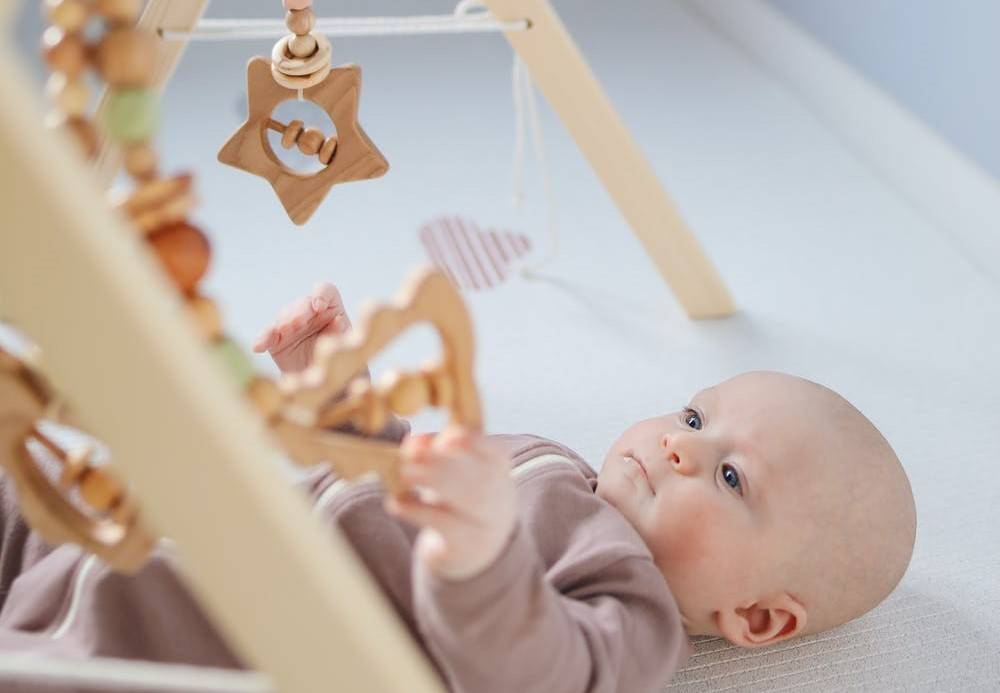 A baby facing different rattles