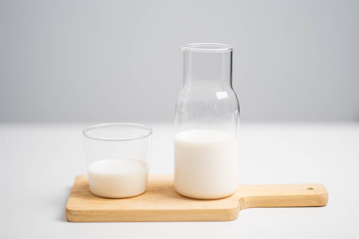 A glass and a bottle of milk