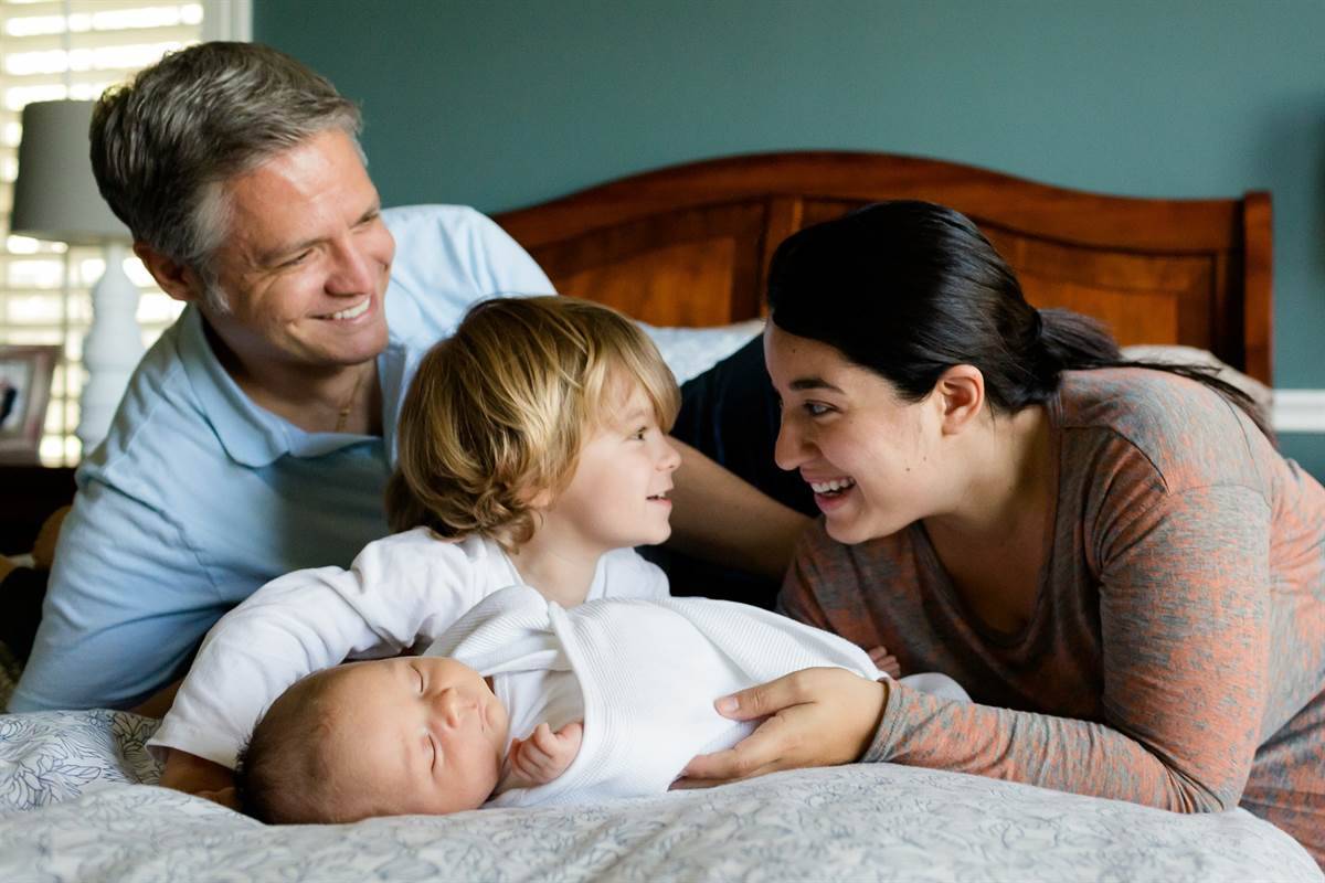 A happy family with two children laughing and looking at each other