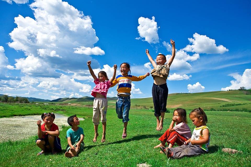 children jumping on a field