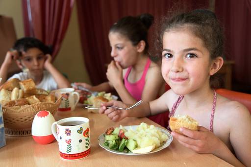 siblings sitting at the table and enjoying lunch