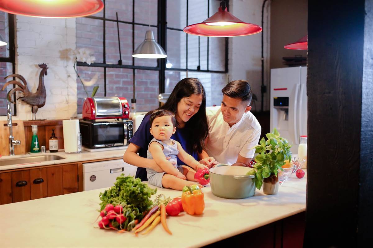 mother and father standing with baby in the kitchen