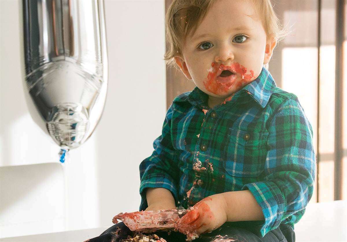 Messy baby with cupcake smeared around their mouth