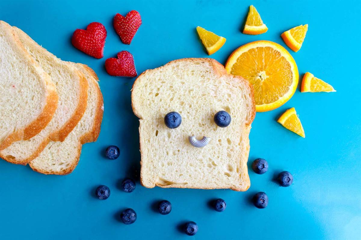 toast, berries and orange slices arranged into a picture 