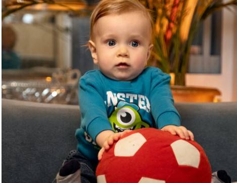 baby holding onto a soft ball