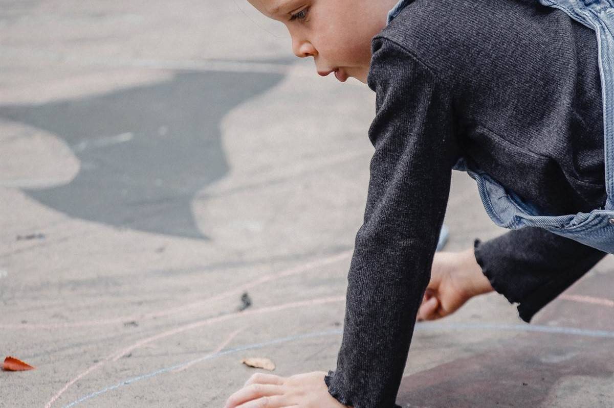 girl drawing with chalk on the street