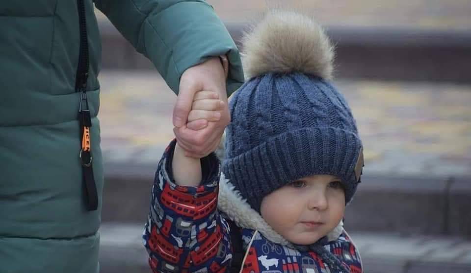 дитина тримається за руку дорослого