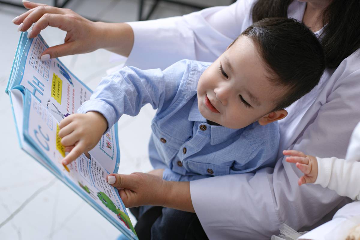 Unicefkg\Ergashev\Мама учит сына читать, держа книгу