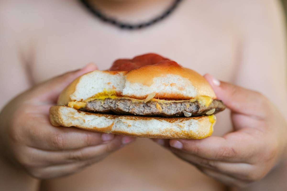 Person holding cheeseburger