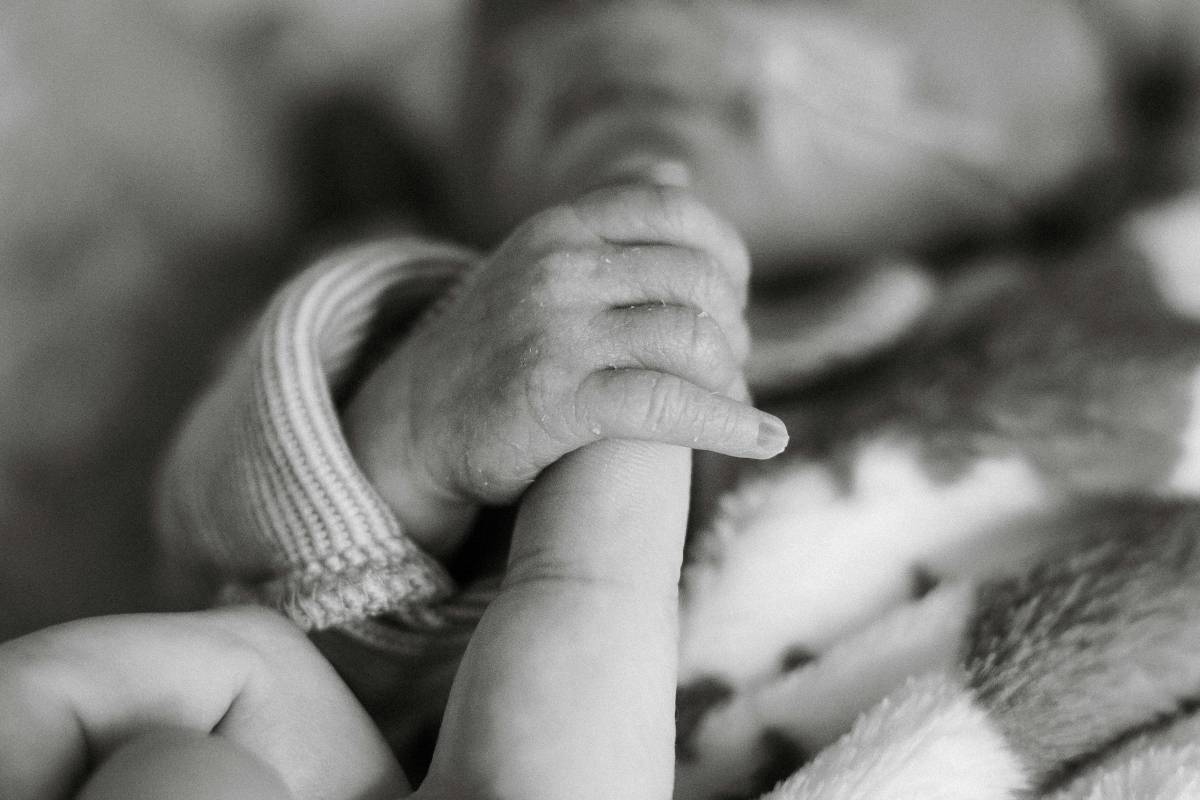 Parent holding hand of premature baby