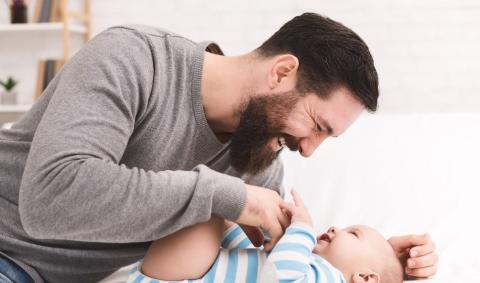 A father doing "buzzings" to his baby.