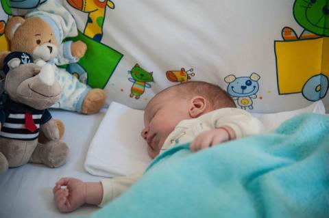 beba spava na boku u krvecu okrenuta ka lutkama