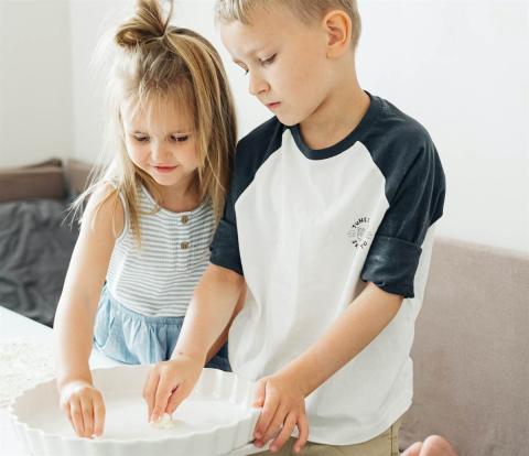 A sister and a brother preparing a pretend meal