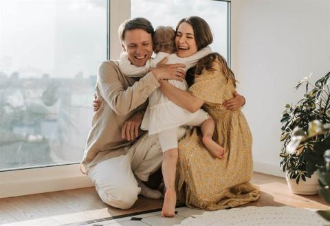 Mother and father hugging their child