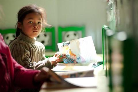 A child with a book ready to tell her story to parents