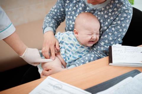 Baby with colic in his mother arms.