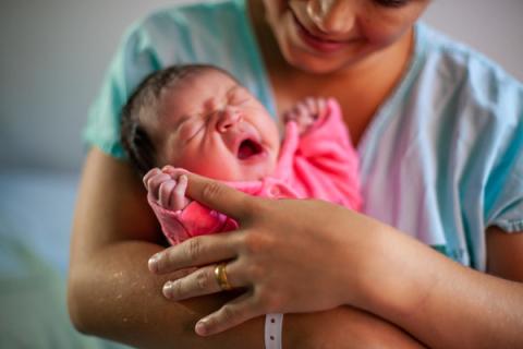 Newborn in the arms of the mother.