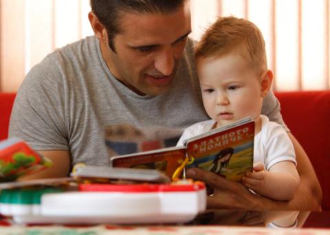 Father engaging in reading with first-born child (2 y.o)