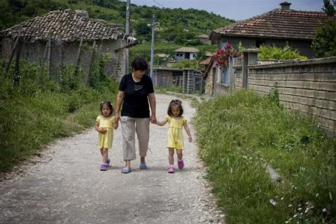 Mother walks outside with her four-year-old twin foster daughters
